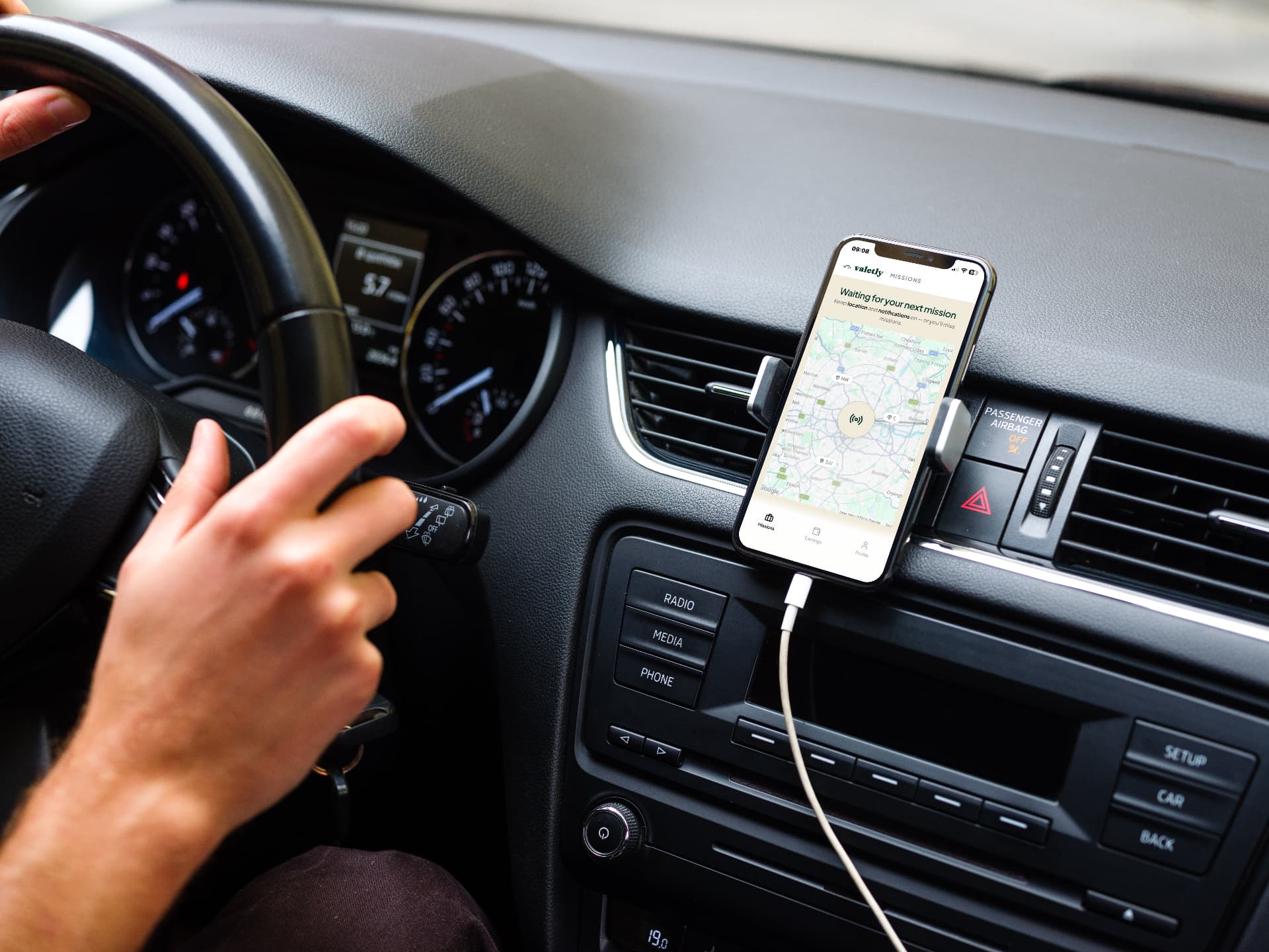 Valetly app on a phone mounted in a car, showing live mission requests on the map