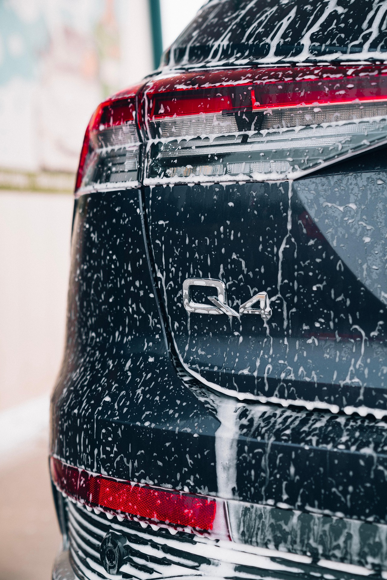 Exterior car wash in progress on a dark SUV